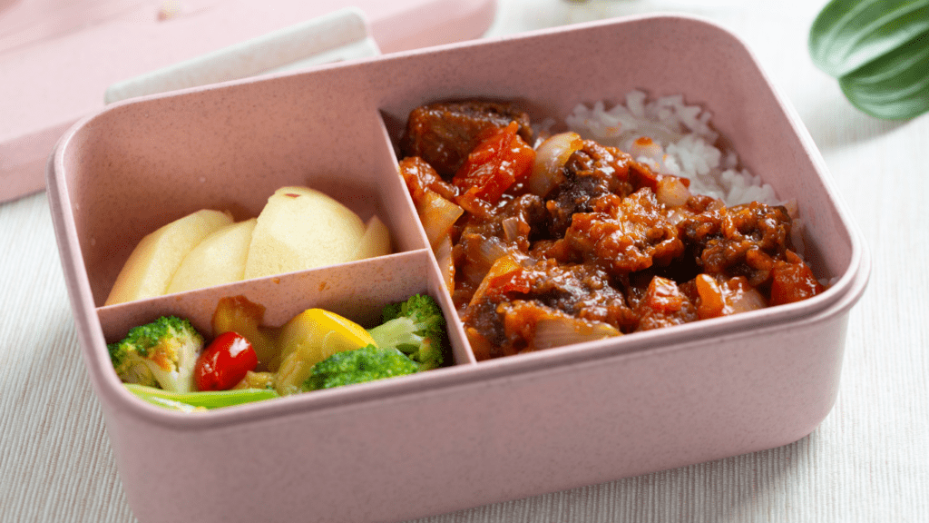 a lunch box with meat and vegetables