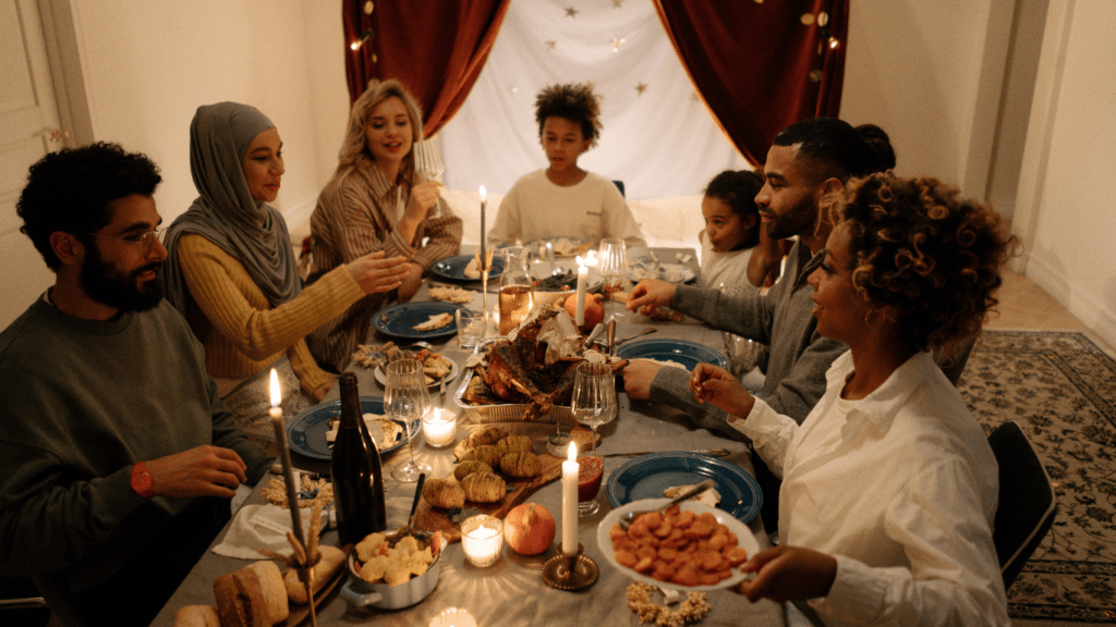 a group of people sitting around a dinner table with food