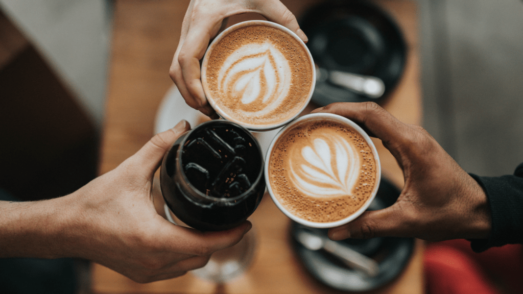 a person holding a cup of coffee with a latte art