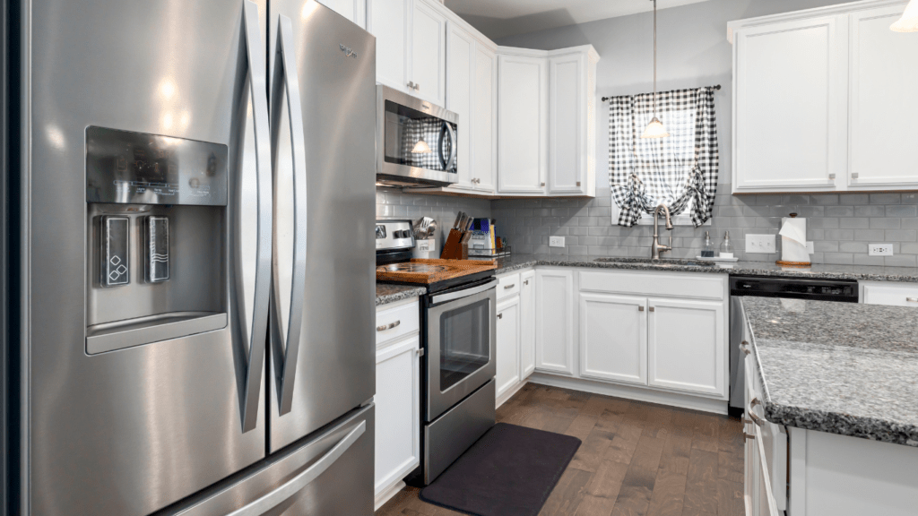 a clean kitchen with white cabinets and hardwood floors