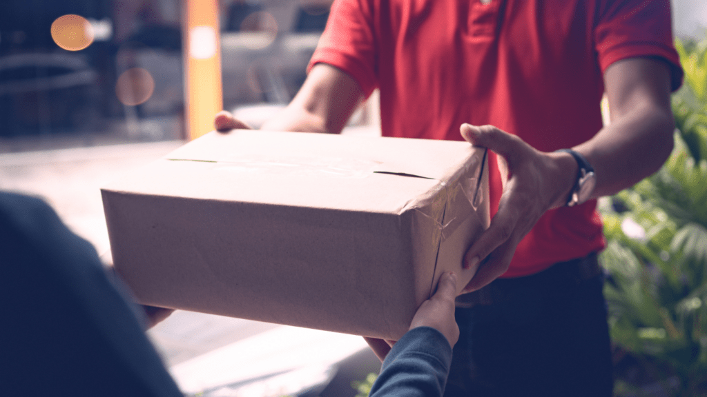 a person handing a brown paper bag to another person