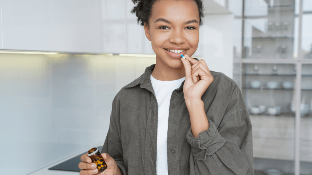 a person holding a vitamin pill in their hand