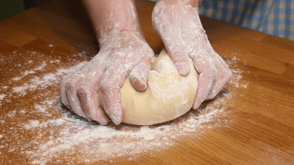 a person is kneading dough on a counter