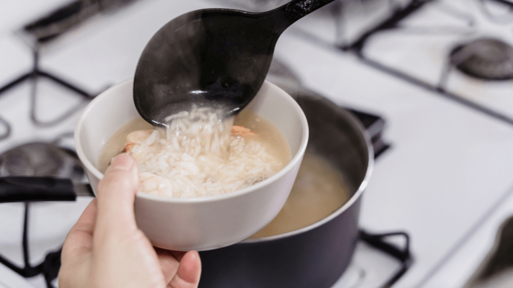 a person pouring sauce into a pot on a stove