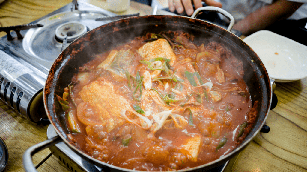 a pot filled with soup and vegetables sitting on top of a table