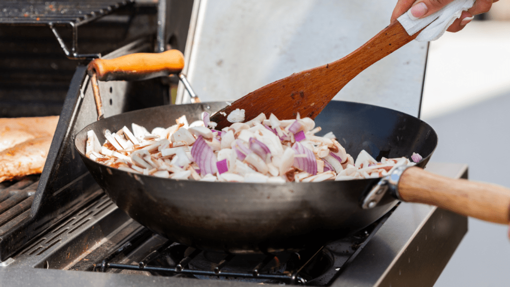 a wok with food in it being stirred with a spoon