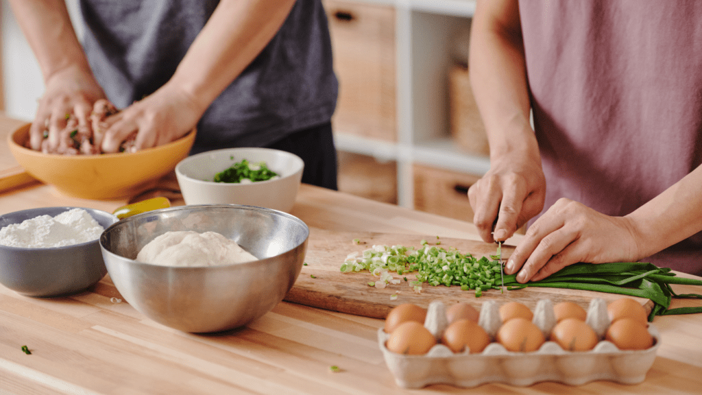 two people in aprons preparing food in the kitchen